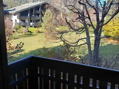 a balcony with a view of a house and a yard at Studio confortable rénové en résidence verdoyante à Chamonix - FR-1-517-69 in Chamonix-Mont-Blanc