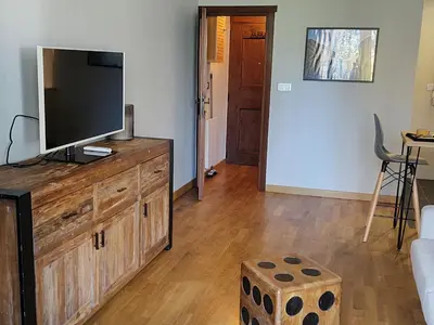 a living room with a television on a wooden dresser at Studio confortable rénové en résidence verdoyante à Chamonix - FR-1-517-69 in Chamonix-Mont-Blanc