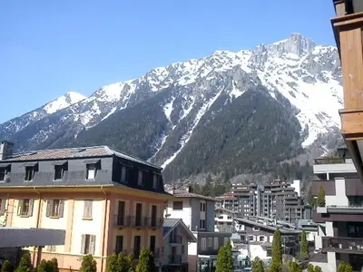 a city with a snow covered mountain in the background at Evasion Sérénité à Chamonix Mont-Blanc in Chamonix-Mont-Blanc