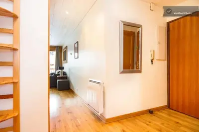 an empty room with a hallway with a door and wooden floors at Evasion Sérénité à Chamonix Mont-Blanc in Chamonix-Mont-Blanc