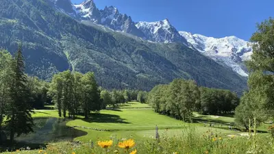 a golf course with mountains in the background at Evasion Sérénité à Chamonix Mont-Blanc in Chamonix-Mont-Blanc