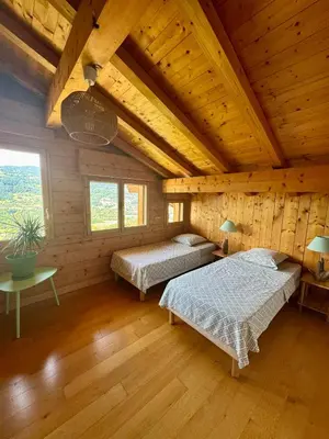 a bedroom with two beds in a wooden cabin at Chalet les vergers in Sallanches