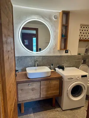 a bathroom with a sink and a washing machine at Chalet les vergers in Sallanches