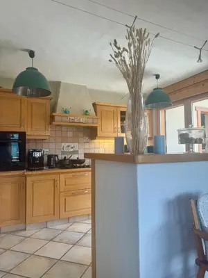 a kitchen with wooden cabinets and a vase on a counter at Chalet les vergers in Sallanches