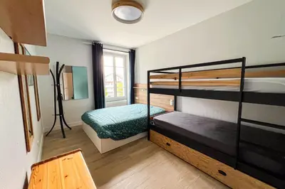 a kitchen with white cabinets and a wooden table at Spacious T2 in the heart of Chamonix in Chamonix-Mont-Blanc