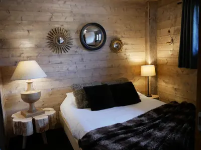 a bedroom with a bed and two lamps and a mirror at Appartement Panthère in Demi-Quartier