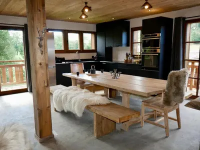 a large kitchen with a wooden table and a bench at Appartement Panthère in Demi-Quartier