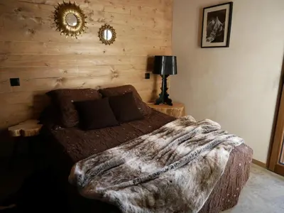 a bedroom with a large bed with a blanket at Appartement Panthère in Demi-Quartier
