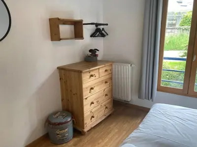 a bedroom with a dresser and a bed and a window at Appartement familial en résidence Saint Gervais les bains in Saint-Gervais-les-Bains