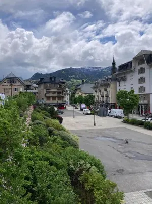 a town with buildings and a parking lot with cars at Appartement familial en résidence Saint Gervais les bains in Saint-Gervais-les-Bains