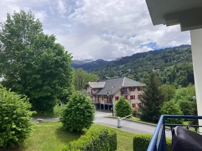 a house on the side of a road with trees at Appartement familial en résidence Saint Gervais les bains in Saint-Gervais-les-Bains