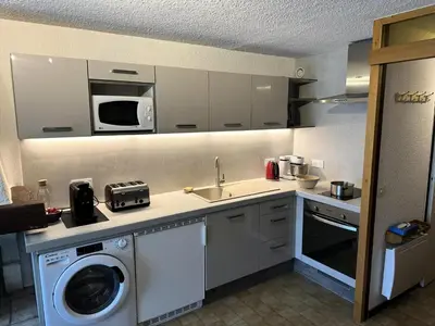 a kitchen with a washing machine and a microwave at Résidence Ecrin Des Glacier Ecureuil - ECRIN DES GLACIERS ECUREUIL 4 MAE-4011 in Combloux
