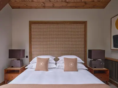 a bedroom with a white bed with two pillows at Chalet Molitor, avec services, Collection Chalets des Fermes in Megève