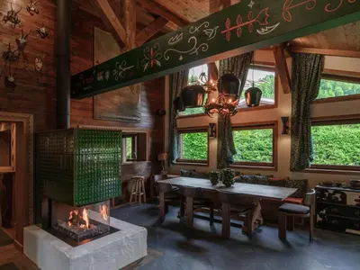 a dining room with a fireplace and a table at Chalet Molitor, avec services, Collection Chalets des Fermes in Megève