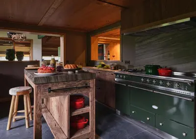 a kitchen with a stove and a counter with a table at Chalet Molitor, avec services, Collection Chalets des Fermes in Megève
