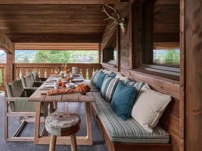 a dining room with a long table and a couch at Chalet Molitor, avec services, Collection Chalets des Fermes in Megève