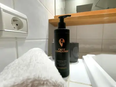 a black bottle of soap on a sink in a bathroom at Les Carlines in Les Contamines-Montjoie