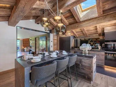 a kitchen with a large island with bar chairs at Chalet d'Exception à Megève avec Piscine et Cinéma - FR-1-569-194 in Megève
