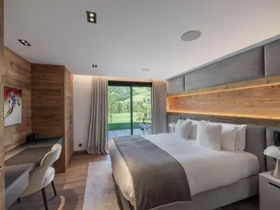 a bedroom with a large bed and a large window at Chalet d'Exception à Megève avec Piscine et Cinéma - FR-1-569-194 in Megève