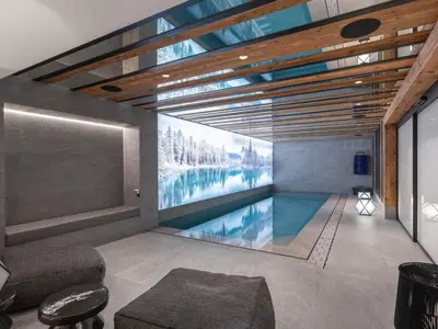 a swimming pool in a house with a large painting on the wall at Chalet d'Exception à Megève avec Piscine et Cinéma - FR-1-569-194 in Megève