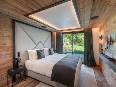 a bedroom with a large bed and a large window at Chalet d'Exception à Megève avec Piscine et Cinéma - FR-1-569-194 in Megève