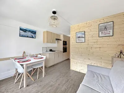 a living room with a table and a kitchen at CL124 Studio cabine cosy 4 pers centre in Les Carroz d'Araches