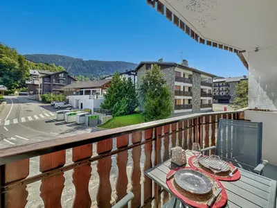 a balcony with a table with plates of food on it at CL124 Studio cabine cosy 4 pers centre in Les Carroz d'Araches