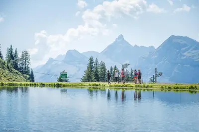 a group of people standing next to a body of water at CL124 Studio cabine cosy 4 pers centre in Les Carroz d'Araches