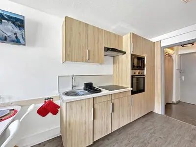 a kitchen with wooden cabinets and a sink at CL124 Studio cabine cosy 4 pers centre in Les Carroz d'Araches