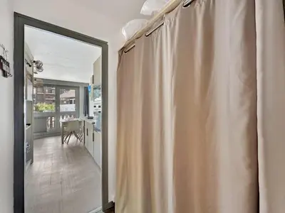 a sliding glass door leading into a kitchen with a shower curtain at CL124 Studio cabine cosy 4 pers centre in Les Carroz d'Araches