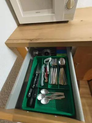 a tray with utensils on a shelf in a microwave at Résidence Vallée Blanche in Sallanches
