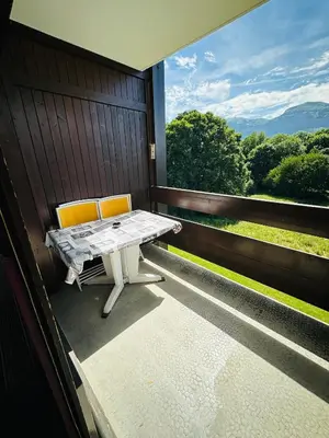 a table and two chairs on a balcony with a view at Studio vue montagne à 200m des pistes in Arâches-la-Frasse