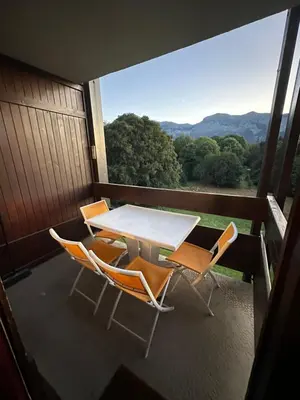 a table and chairs on a balcony with a view at Studio vue montagne à 200m des pistes in Arâches-la-Frasse