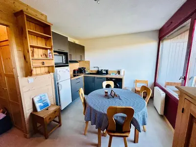 a kitchen with a table and chairs and a kitchen with a table and a kitchen at Studio vue montagne à 200m des pistes in Arâches-la-Frasse