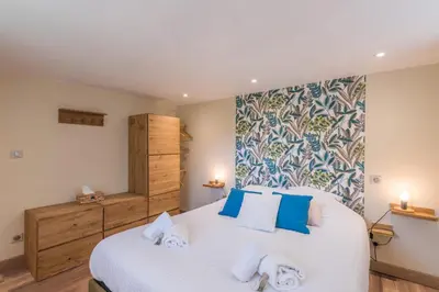 a bedroom with a large white bed with blue pillows at Appartement Couttet - Welkeys in Chamonix-Mont-Blanc
