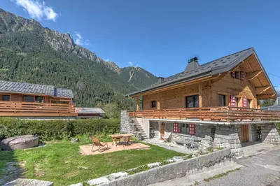a wooden house with a picnic table in front of it at Appartement Couttet - Welkeys in Chamonix-Mont-Blanc