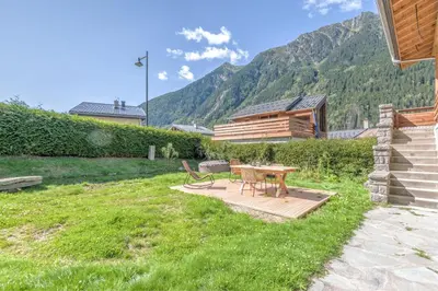 a picnic table in a yard with mountains in the background at Appartement Couttet - Welkeys in Chamonix-Mont-Blanc
