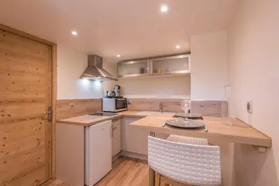 a kitchen with a counter and a sink and a table at Appartement Couttet - Welkeys in Chamonix-Mont-Blanc
