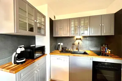 a kitchen with white cabinets and a sink at Cozy Joly in Saint-Gervais-les-Bains