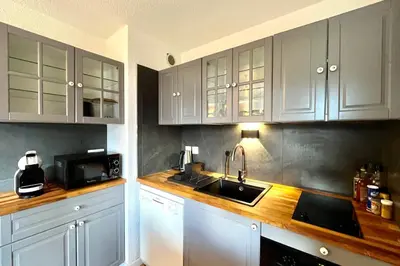 a kitchen with white cabinets and a sink and a microwave at Cozy Joly in Saint-Gervais-les-Bains