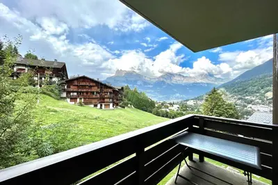 a bench on a balcony with a view of a mountain at Cozy Joly in Saint-Gervais-les-Bains
