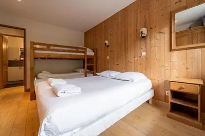 two beds in a room with wooden walls at Bright apartment - near Mont Blanc in Chamonix-Mont-Blanc