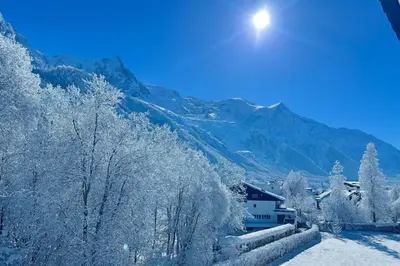 a village covered in snow with mountains in the background at Bright apartment - near Mont Blanc in Chamonix-Mont-Blanc