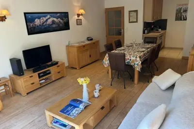 a living room with a dining table and a television at Bright apartment - near Mont Blanc in Chamonix-Mont-Blanc