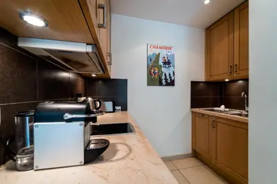 a kitchen with wooden cabinets and a counter top at Bright apartment - near Mont Blanc in Chamonix-Mont-Blanc
