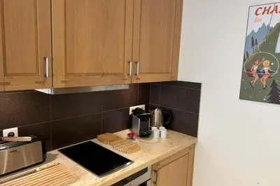a kitchen with wooden cabinets and a counter top at Bright apartment - near Mont Blanc in Chamonix-Mont-Blanc