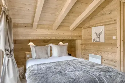 a bedroom with a bed in a log cabin at Harmonie in Demi-Quartier