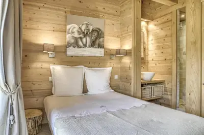 a bedroom with a bed in a wooden room at Harmonie in Demi-Quartier
