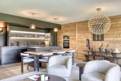 a kitchen with a table and chairs and a counter at Charmant Appartement au Cœur de Megève avec Jardin privatif in Megève