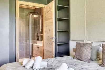 a bedroom with a shower and a bed with towels at Charmant Appartement au Cœur de Megève avec Jardin privatif in Megève